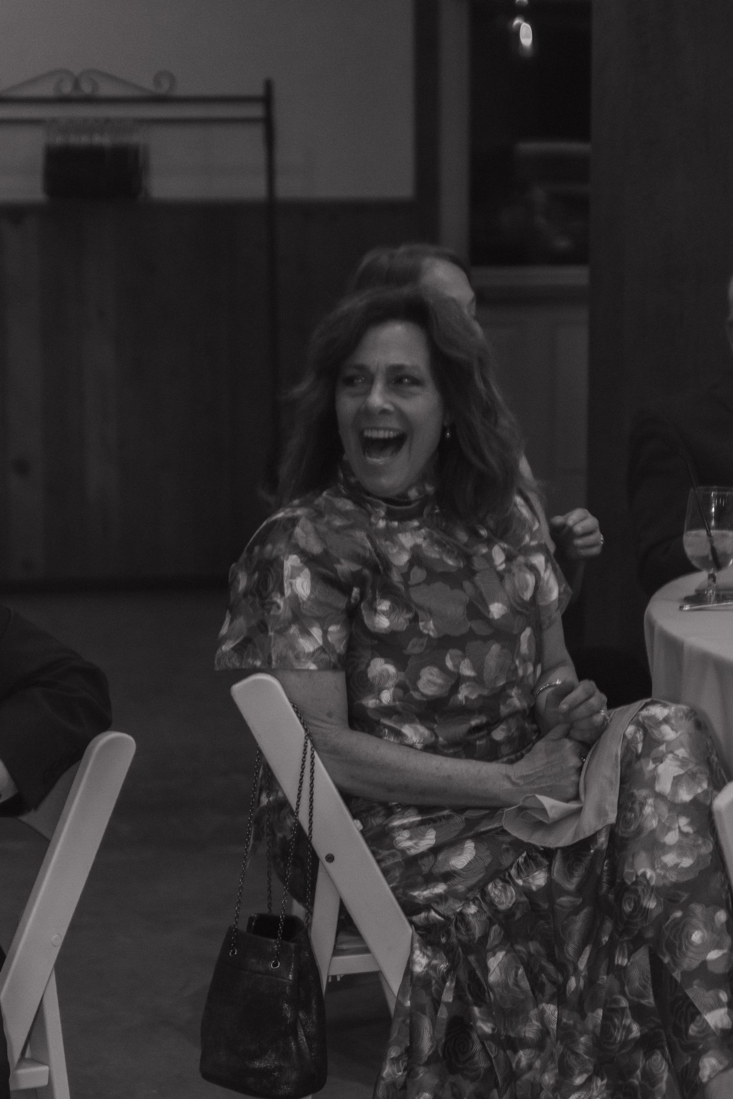 Guest enjoying candid moment during wedding reception in black and white photography.