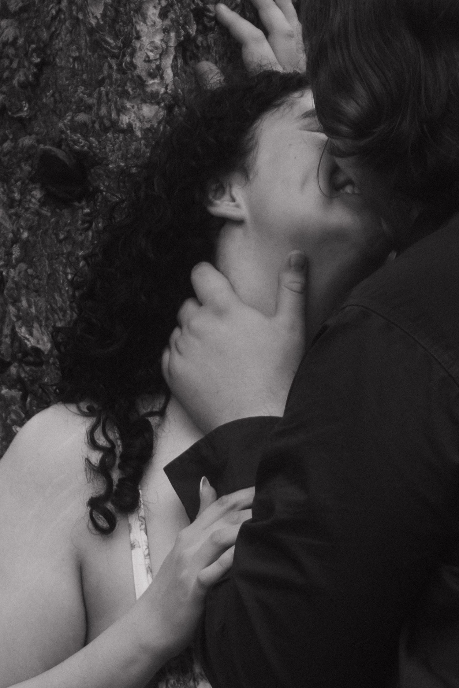 Black and white close-up captures tender romantic embrace in artistic style.