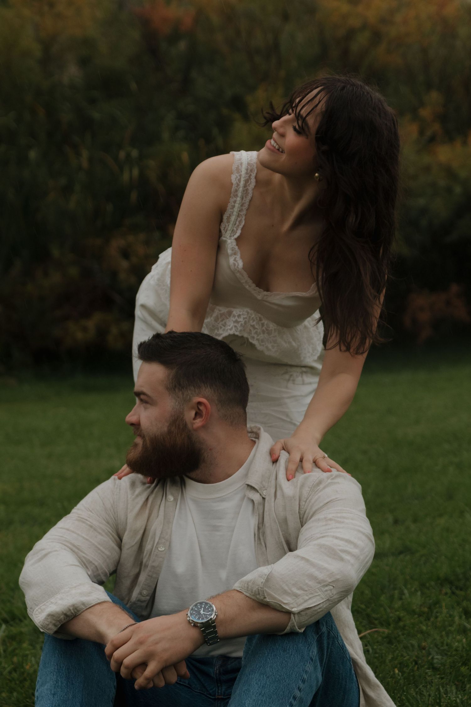 A tender outdoor portrait of a couple with artistic composition against autumn foliage.