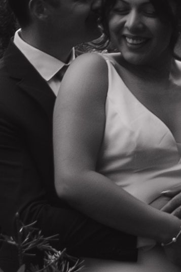 A candid black and white wedding moment showing joy and laughter.