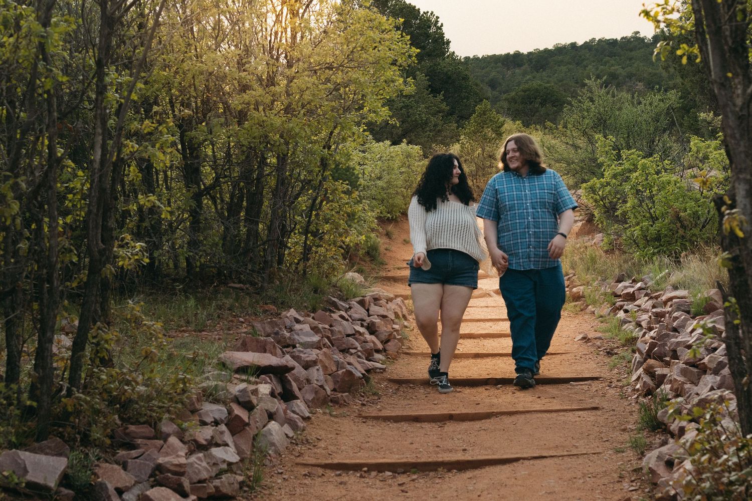 Couple walking together on a scenic desert trail during sunset.