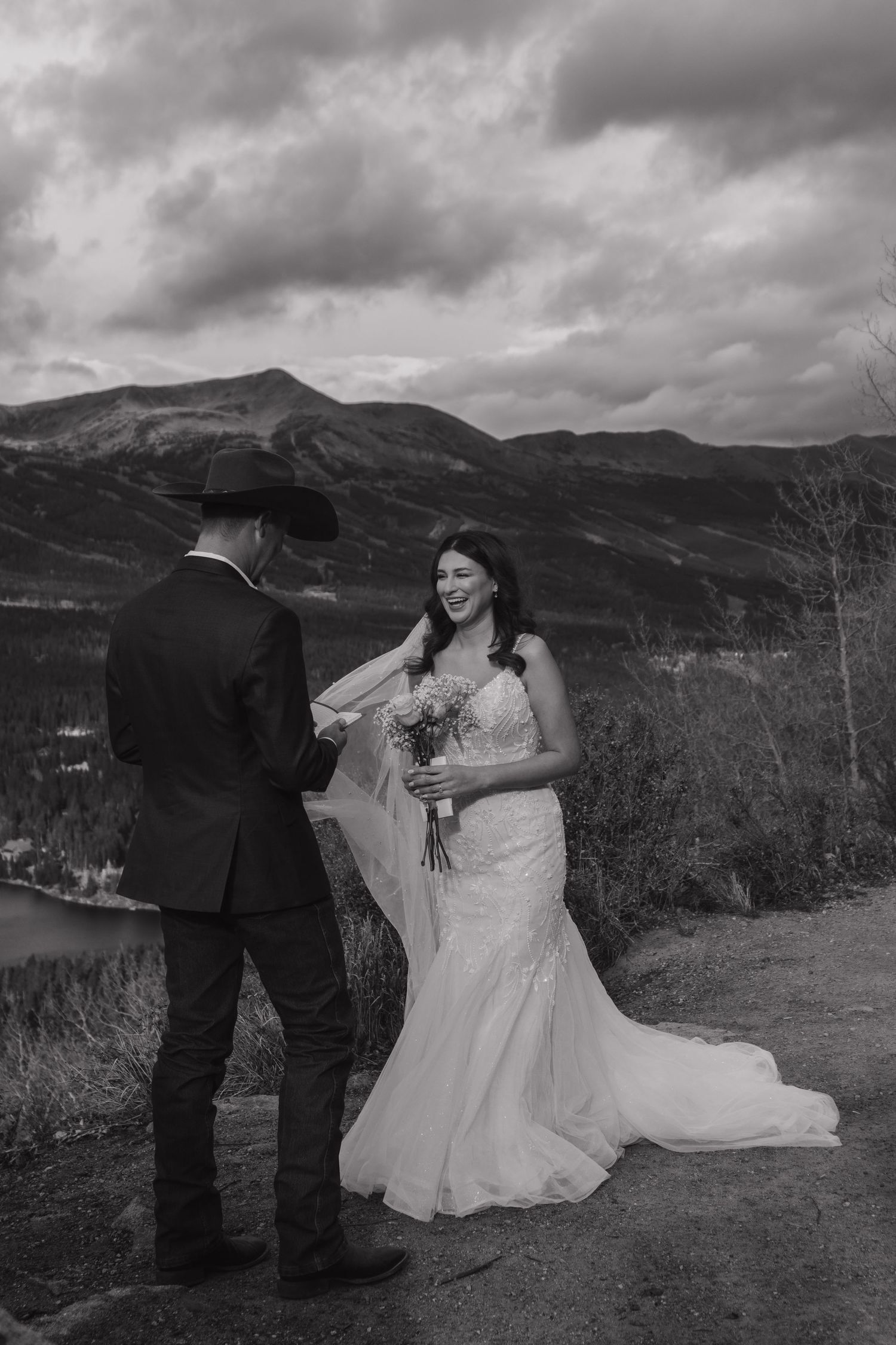 Black and white photo of wedding ceremony against dramatic mountain landscape.