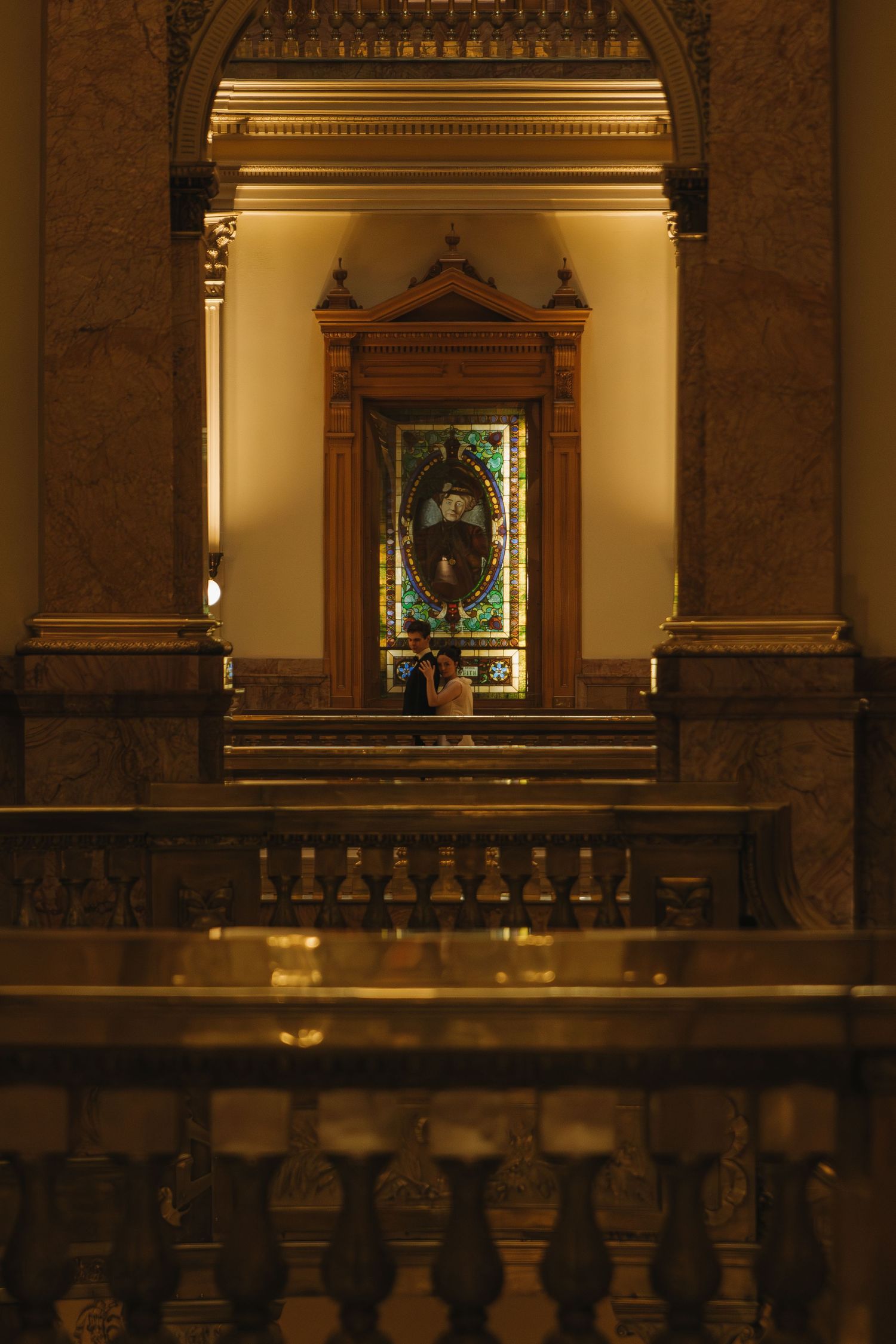 Ornate interior of a historic building with golden lighting and classical architectural details.