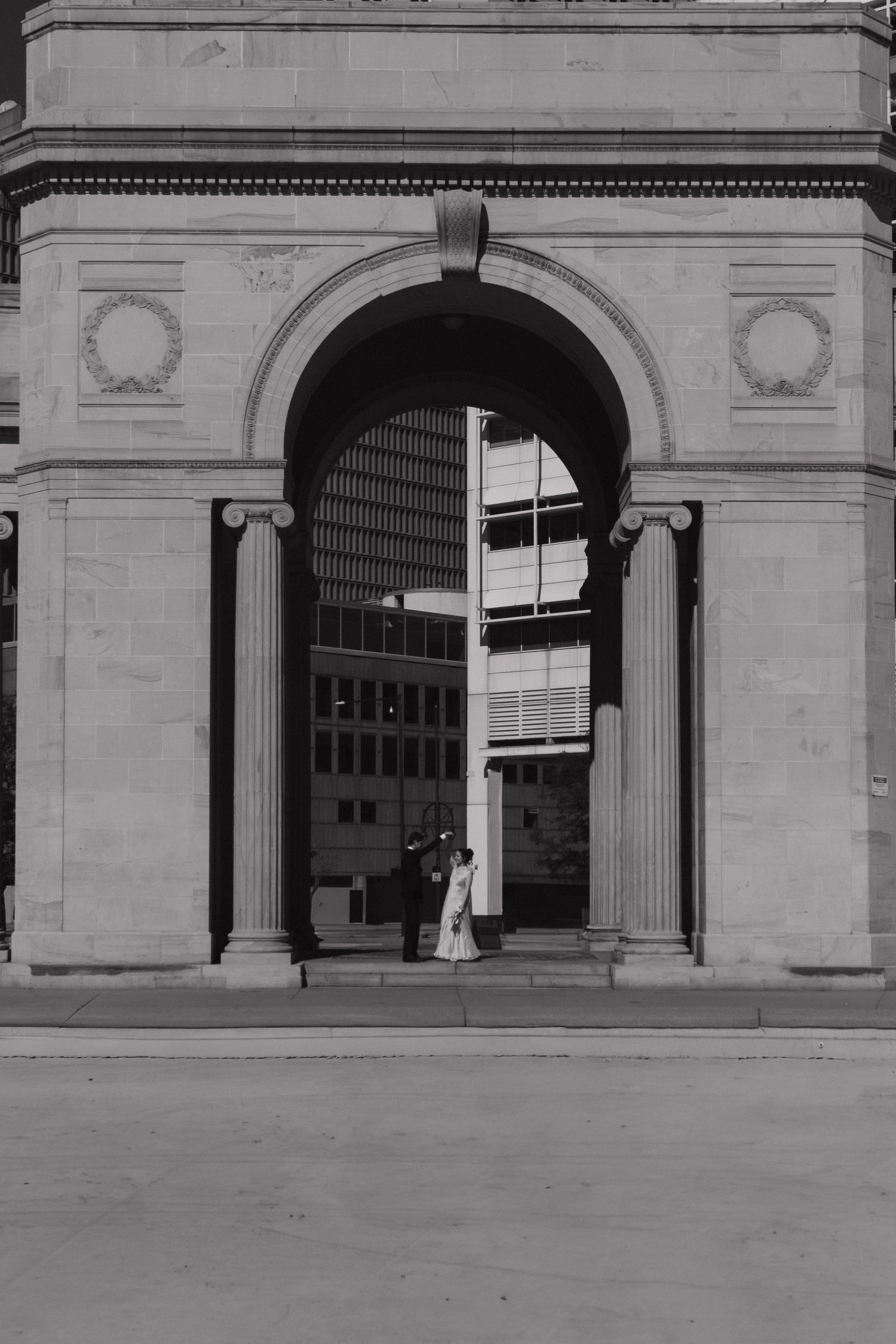 Classical stone archway entrance with Ionic columns in black and white.