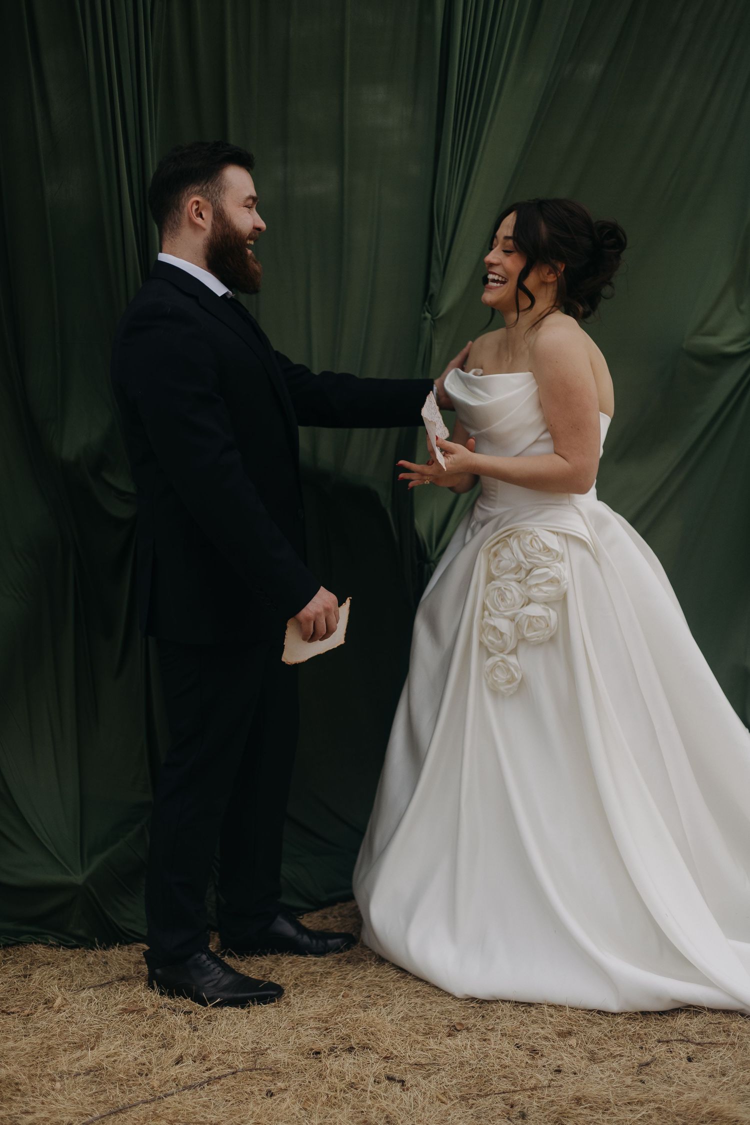Wedding couple in elegant attire sharing intimate moments against dark green backdrop.