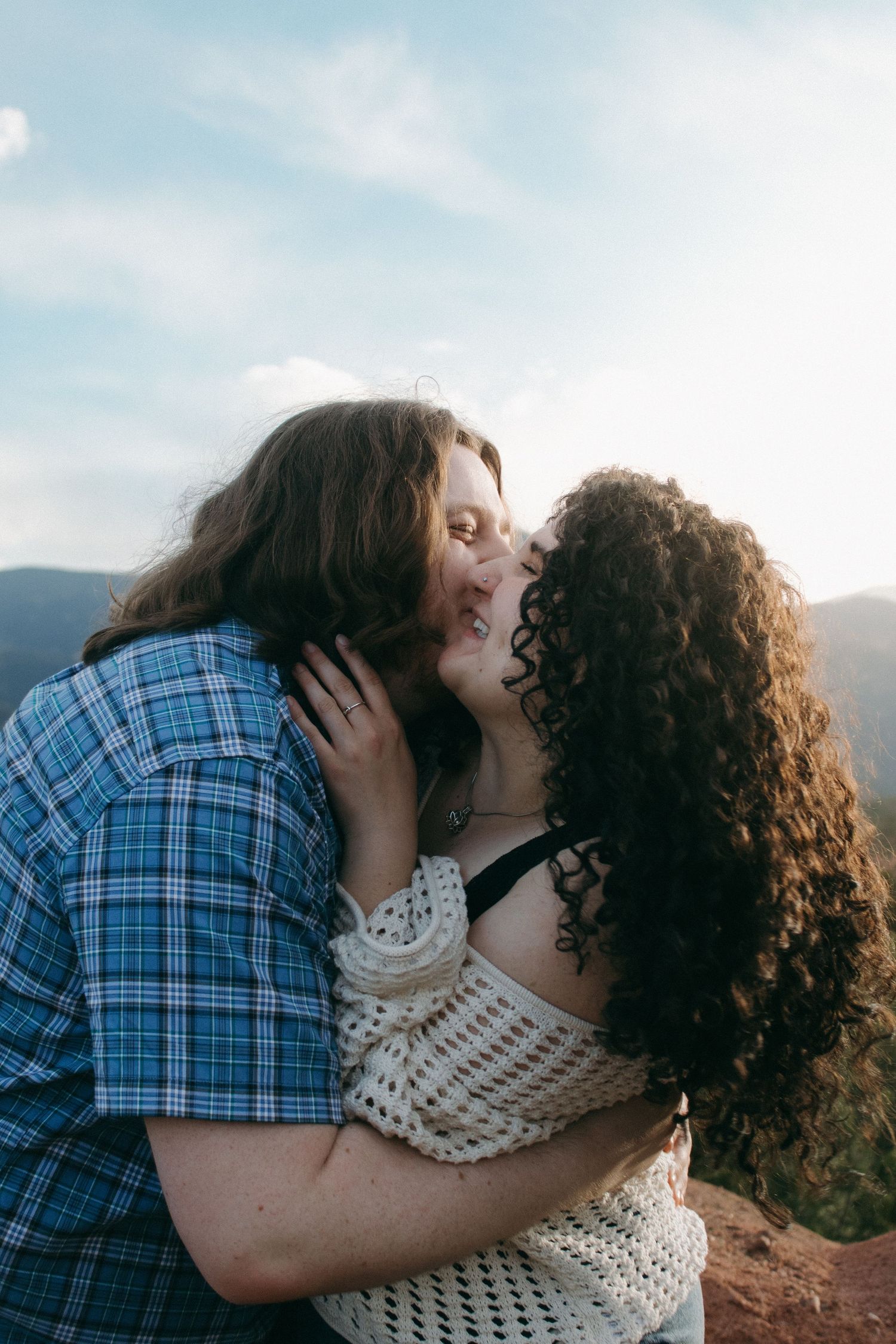 An intimate moment between two people during a sunset mountain photoshoot.
