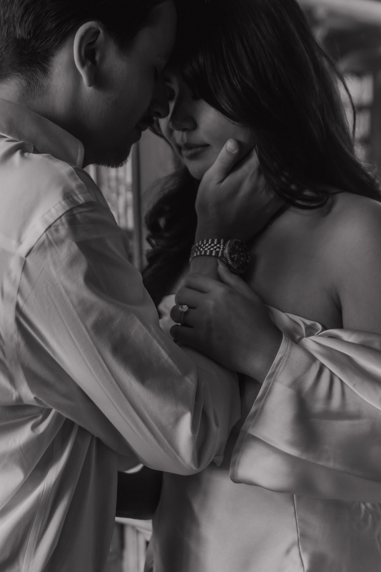 A black and white romantic portrait series showing tender moments between two people.