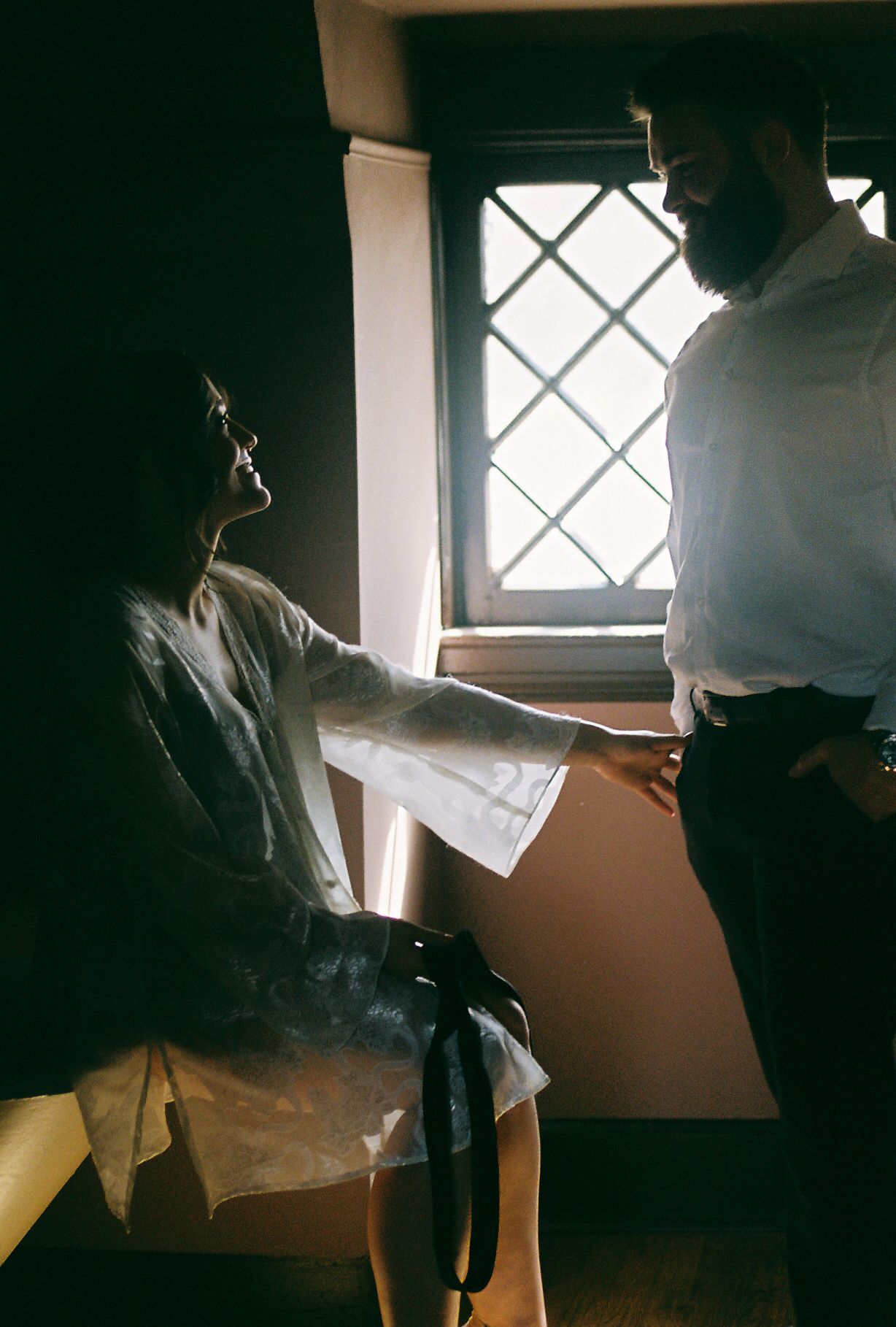 Sunlight streams through windows creating dramatic shadows in a room with white walls.