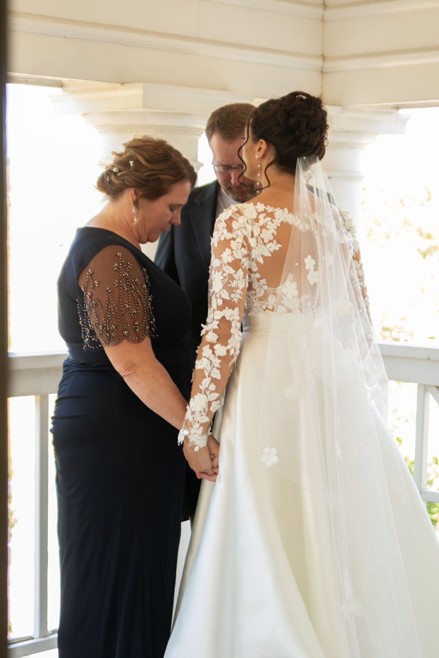An emotional private moment before a wedding ceremony in a bright sunlit room.