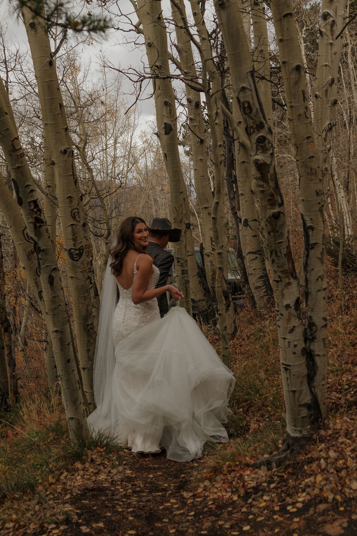 A romantic moment captured in an aspen grove with fallen autumn leaves.