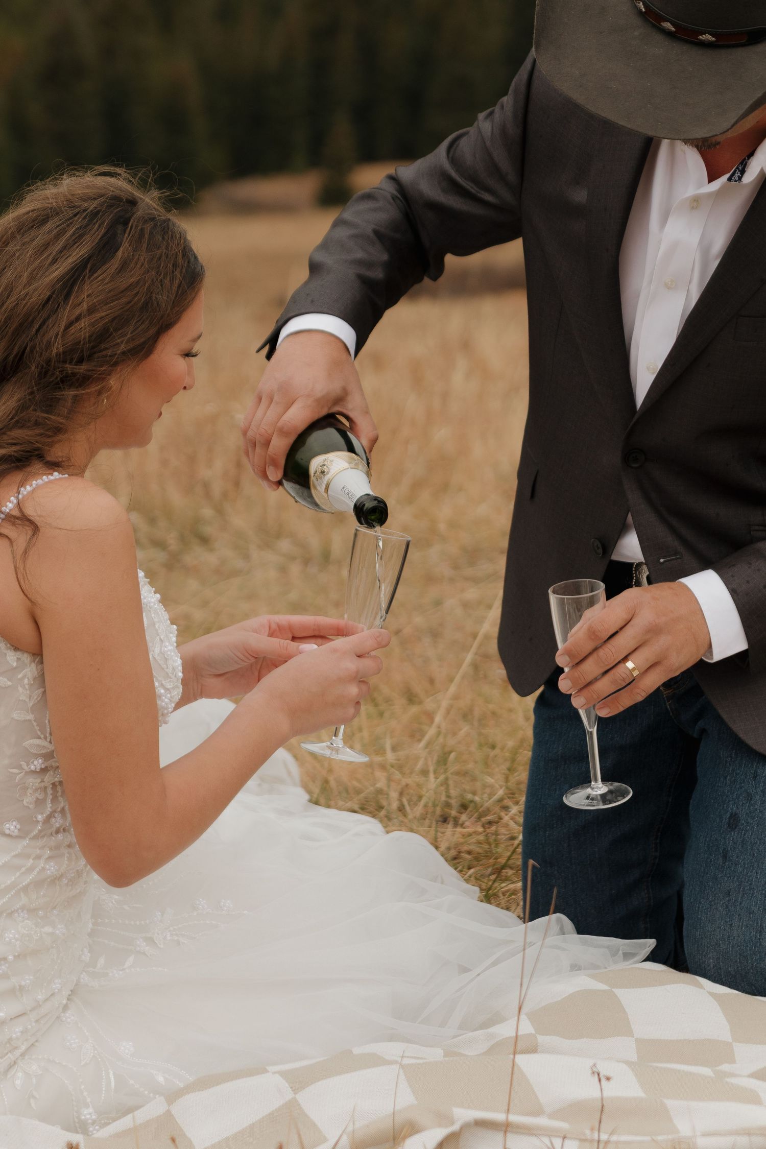 A couple celebrating with champagne during their wedding reception outdoors.