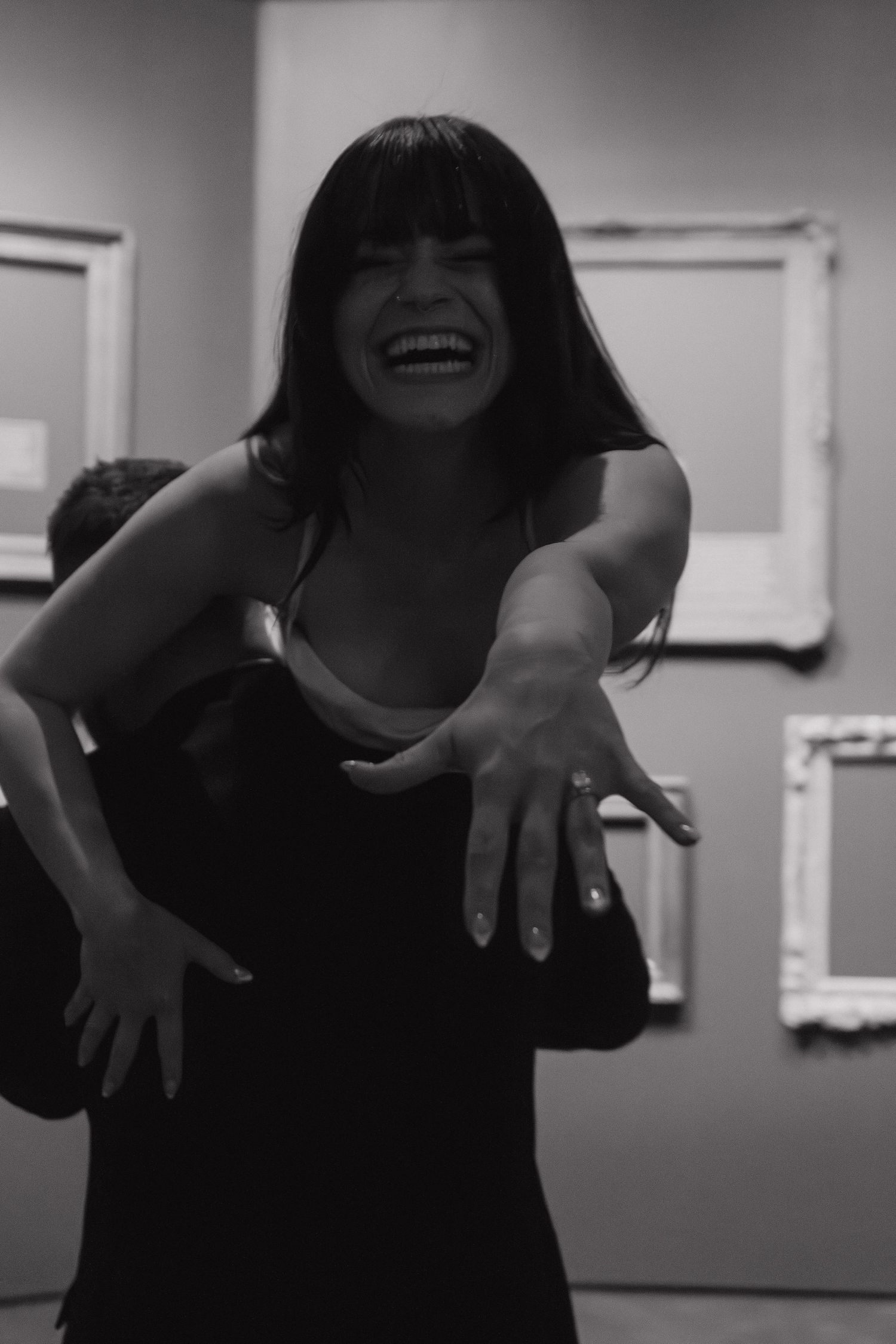 Black and white image capturing energetic dance movements in an indoor studio space.