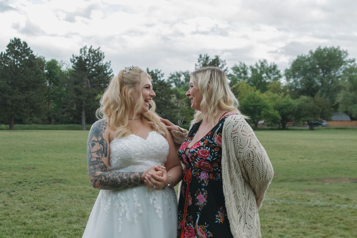 Wedding photo of two people sharing an intimate moment outdoors in a park setting.