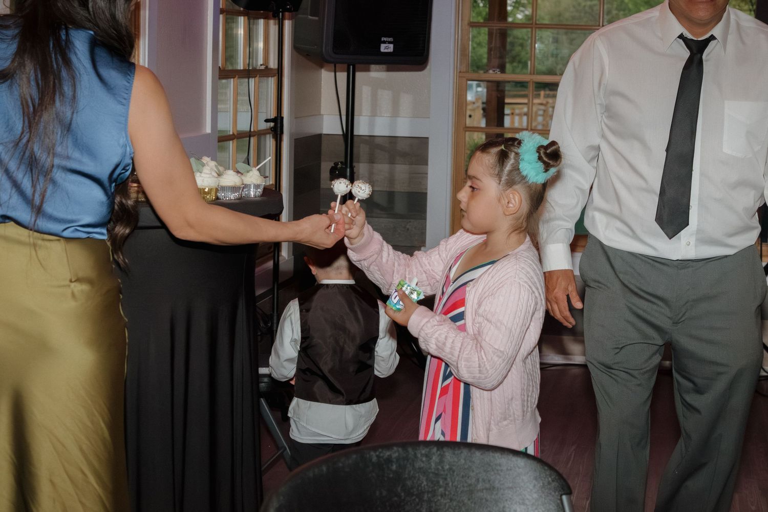 Young guest enjoying refreshments at wedding reception with attendees.