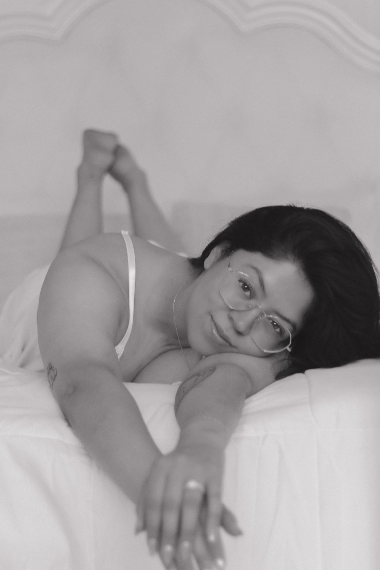 Intimate black and white portrait on white bedding.