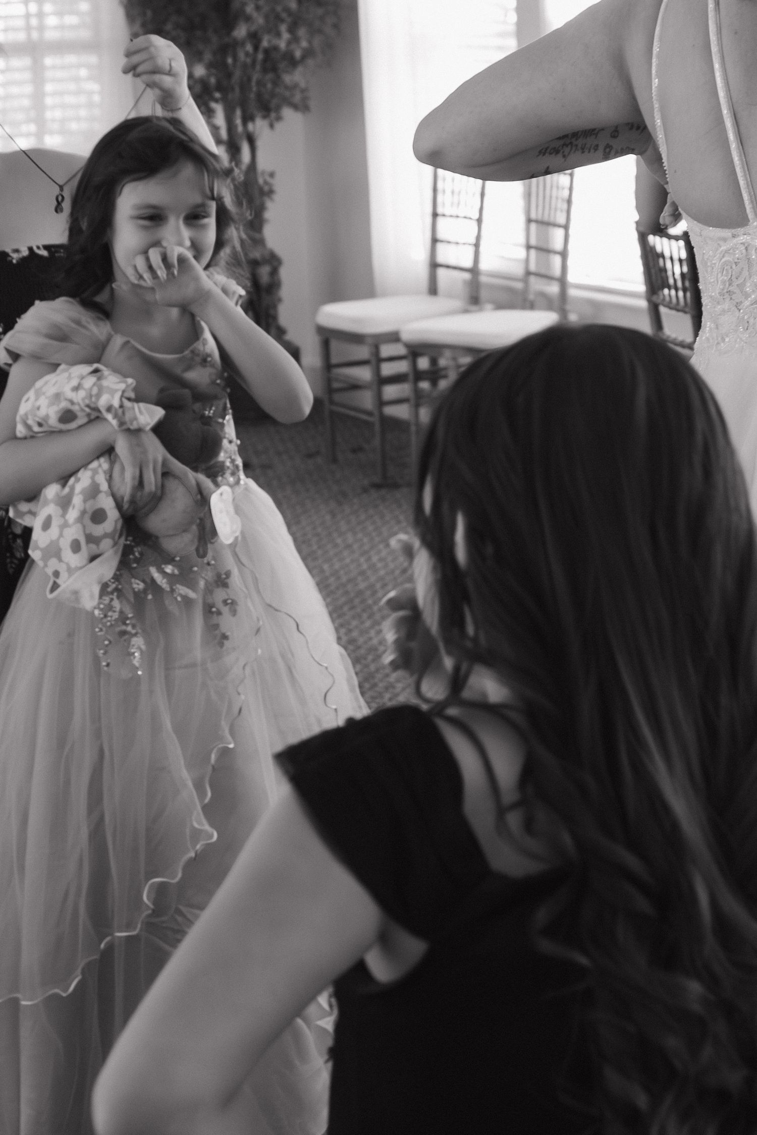 A black and white photo series shows a couple in wedding attire sharing a celebratory drink together.