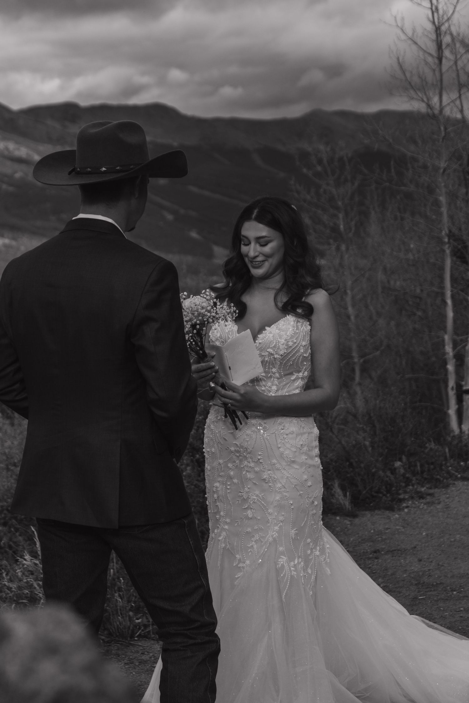 Black and white wedding photos capture intimate moments against a dramatic mountain backdrop.