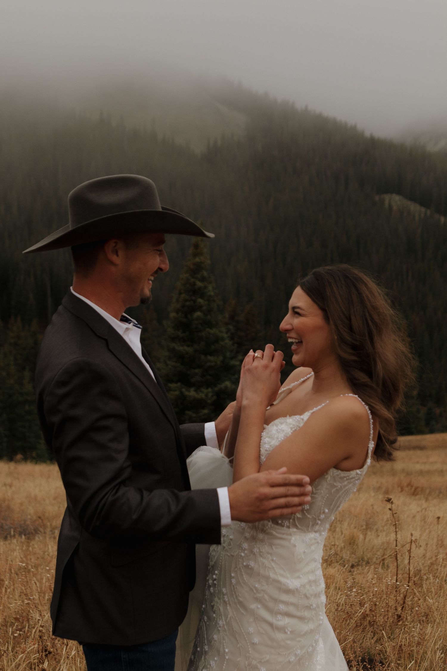 A joyful moment between a couple during their mountain wedding celebration.
