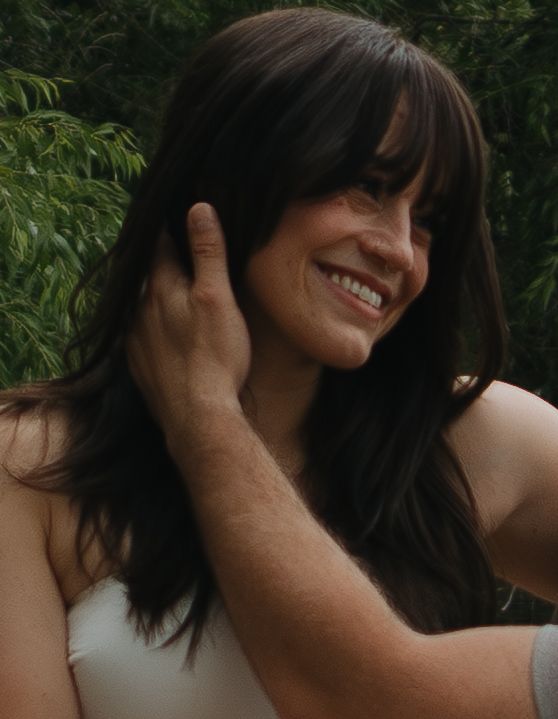 A series of seven close-up outdoor shots showing a person touching their hair and face against a green leafy backdrop.