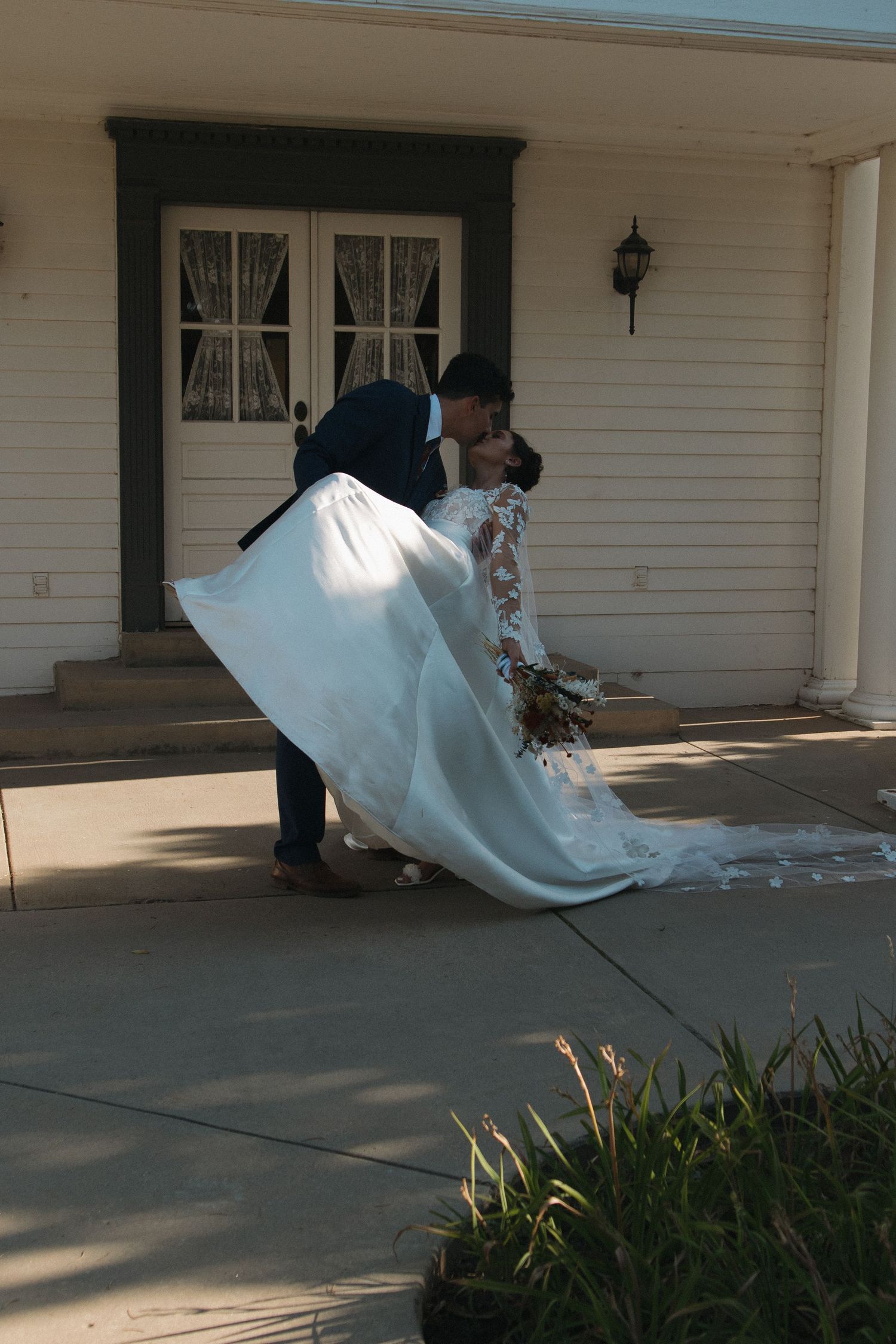 A sequence showing a bride lying down playfully on a concrete porch while having photos taken.