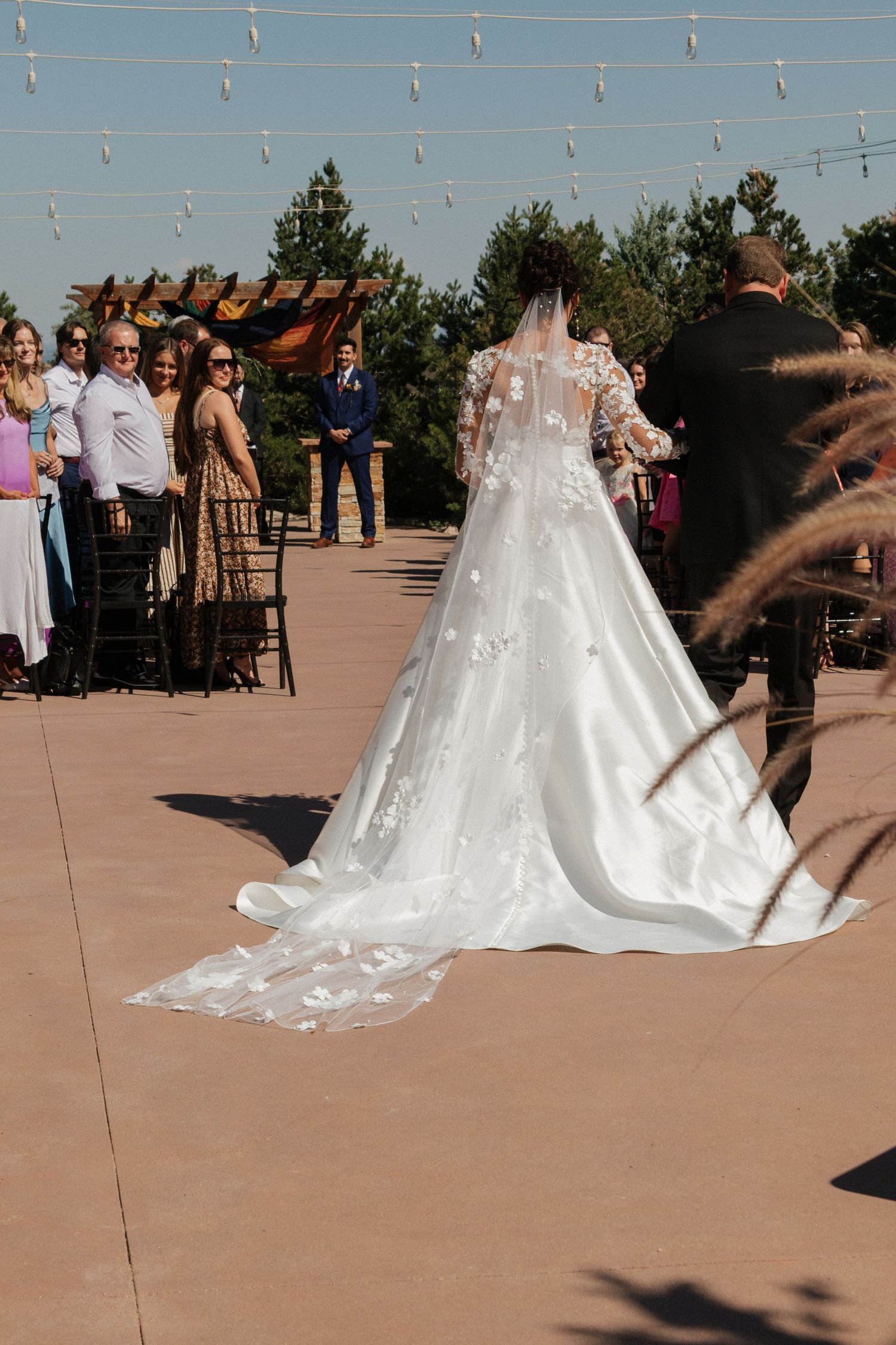 Wedding ceremony setup on an outdoor patio with string lights and mountain views.