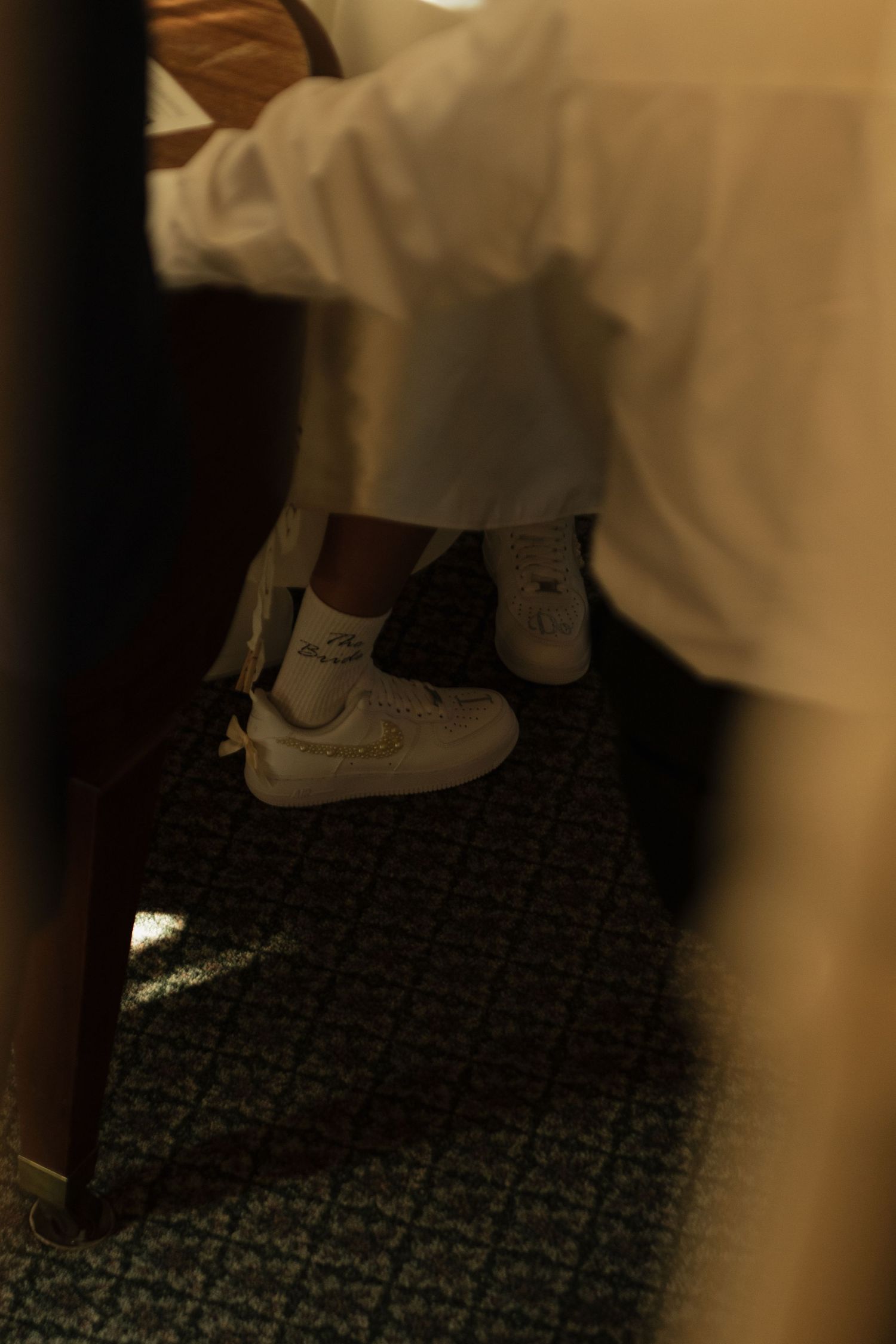 Close-up sequence of shoes on patterned carpet during wedding preparations.