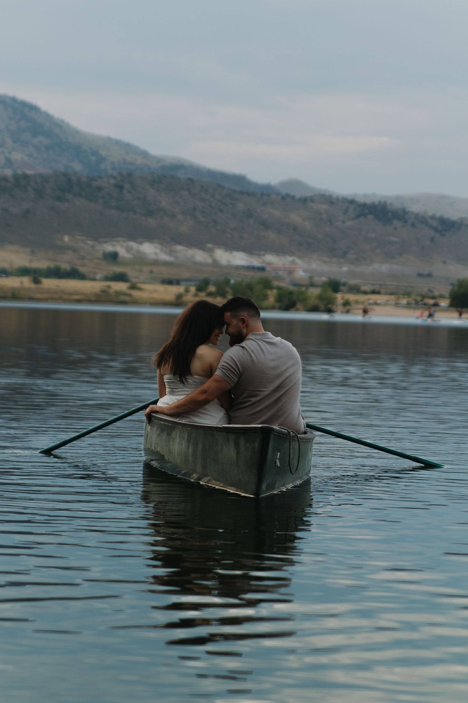 Couple sharing an intimate moment in a canoe on a mountain lake.