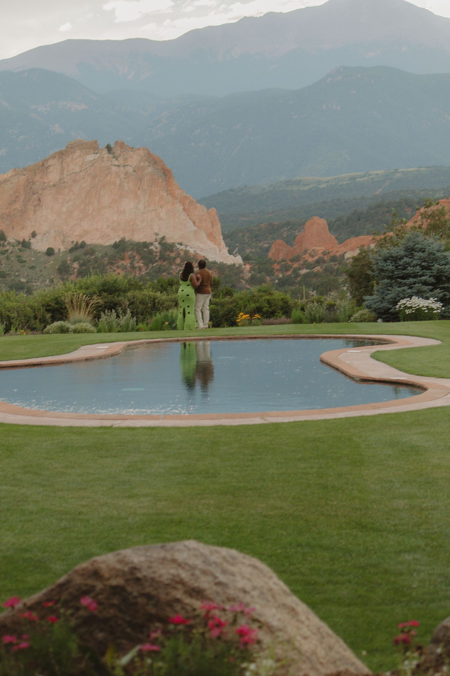 A scenic pool reflects red rock formations and mountains at Garden of the Gods in Colorado Springs.