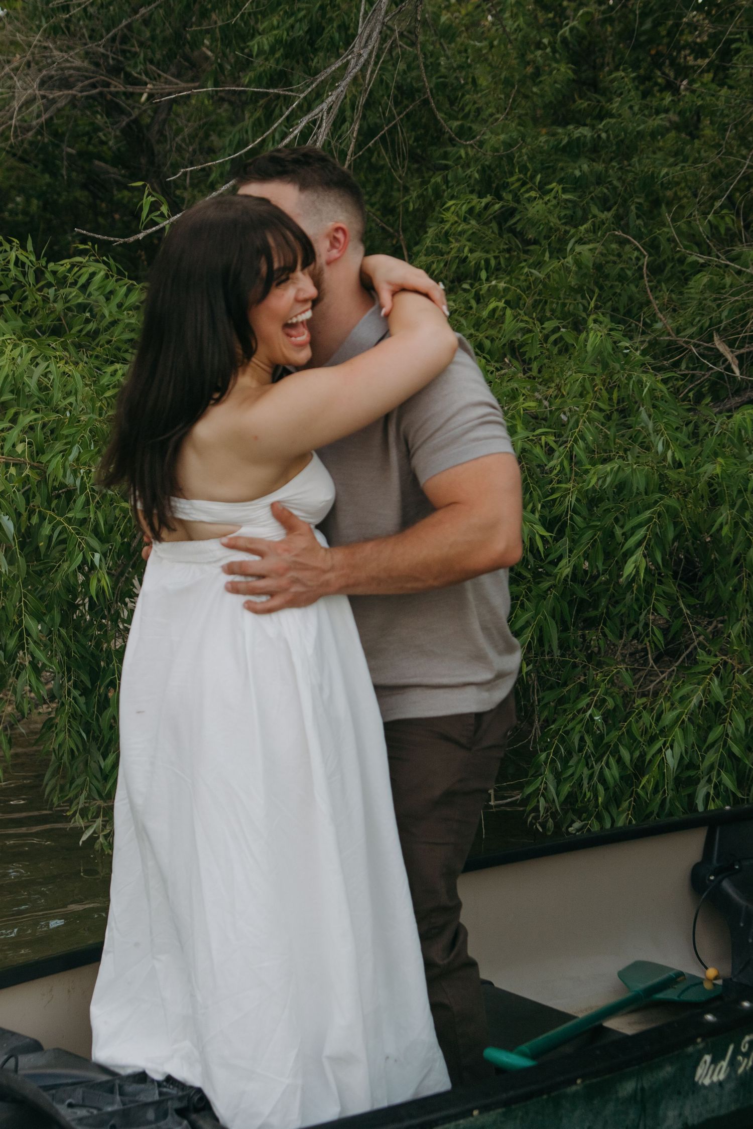 A couple shares intimate moments in a series of photos along a riverbank with lush greenery in the background.