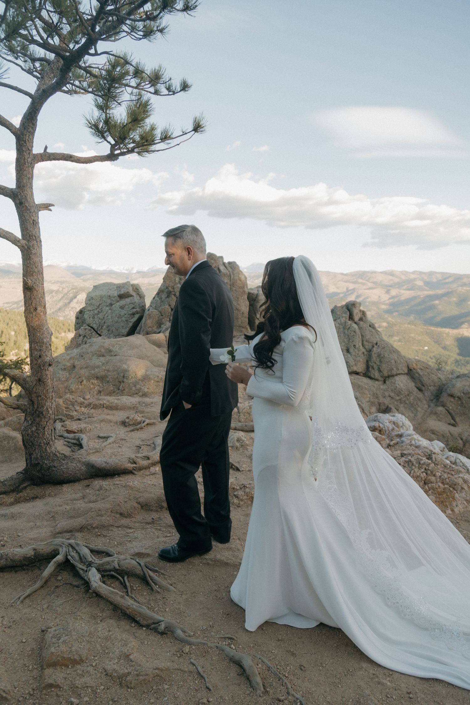 Bride and groom exchanging vows on a rocky mountain overlook with sweeping valley views.