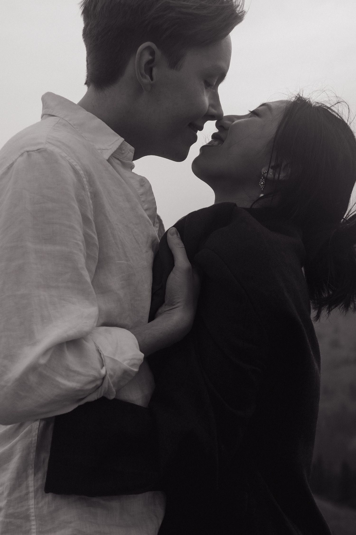 Black and white close-up of couple nearly kissing and smiling intimately during their outdoor elopement.