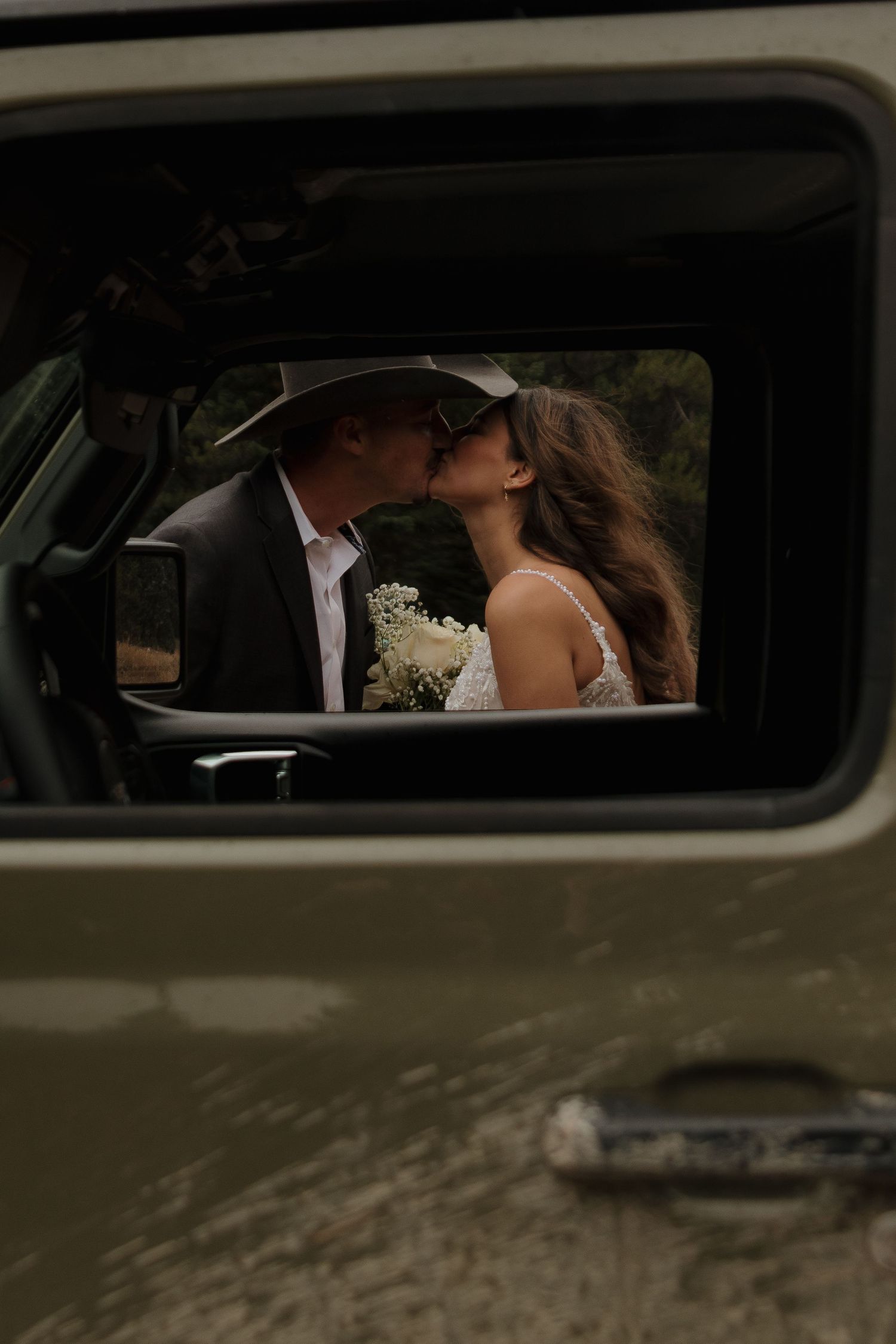 A romantic moment viewed through a vintage car window frame.