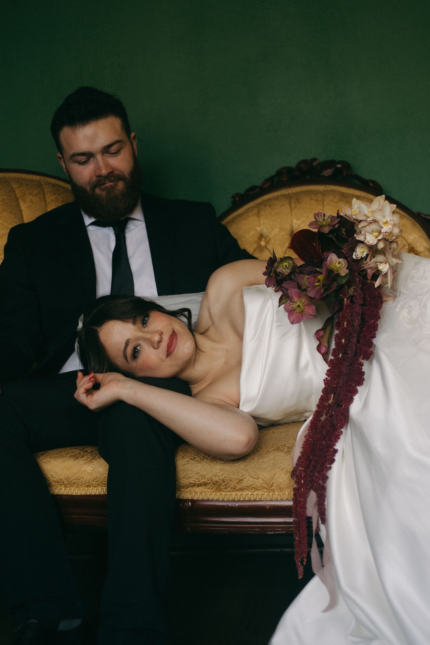 A series of artistic wedding portraits showing a person in white dress reclining on a vintage chaise lounge against dark backdrop.