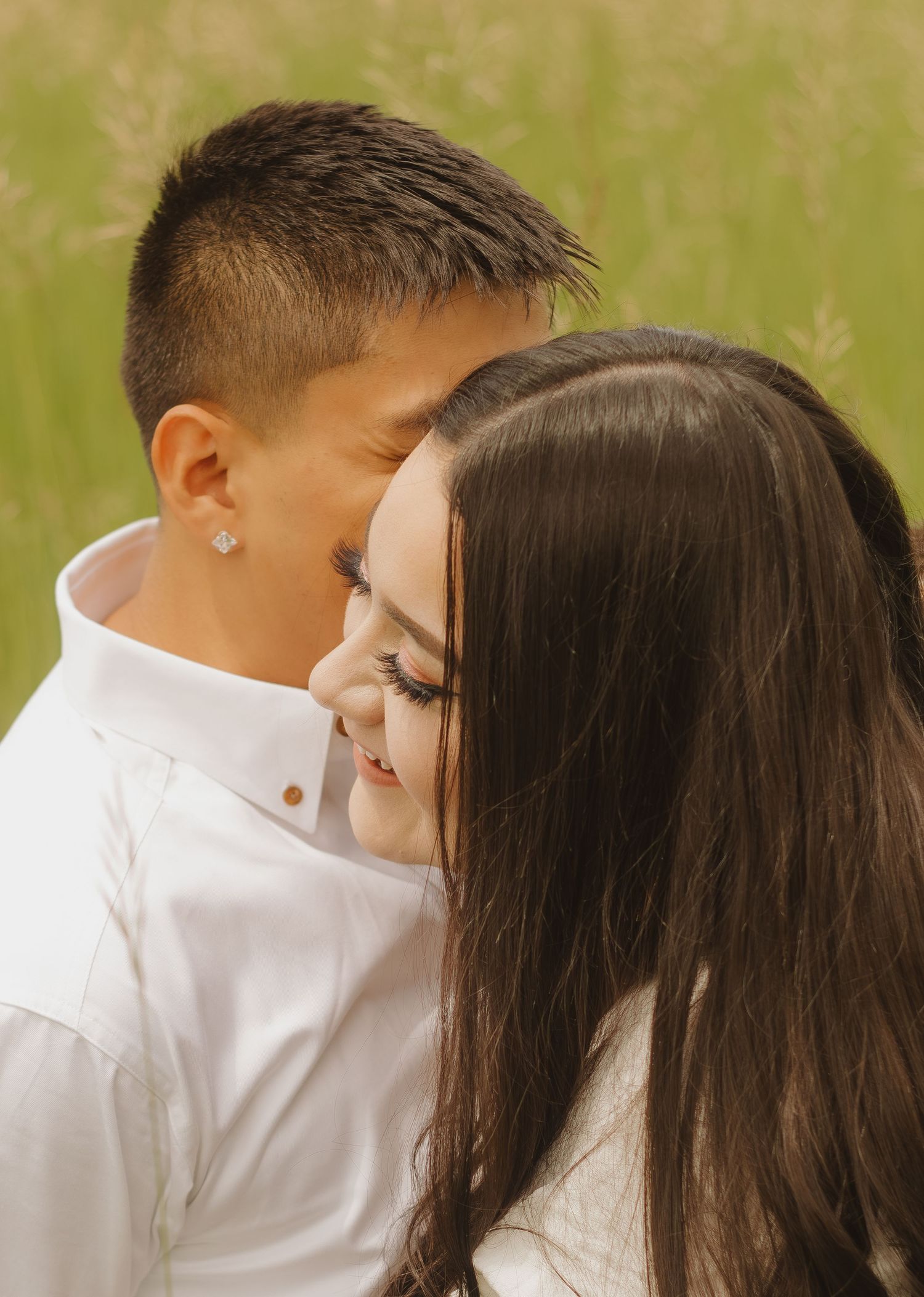 Close-up portrait of a couple sharing an intimate moment in natural outdoor lighting.
