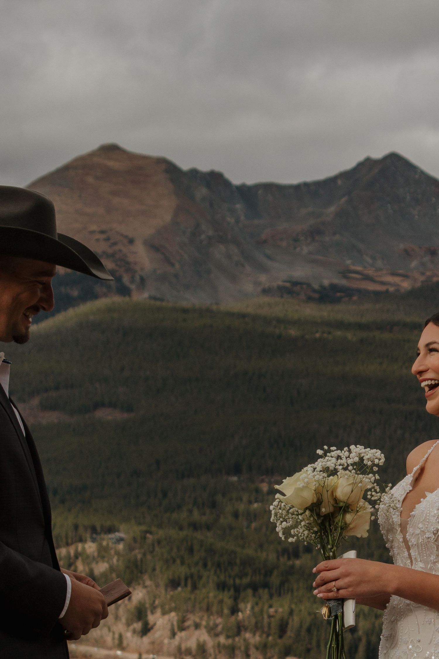 A mountain wedding ceremony with dramatic peaks and forest backdrop.