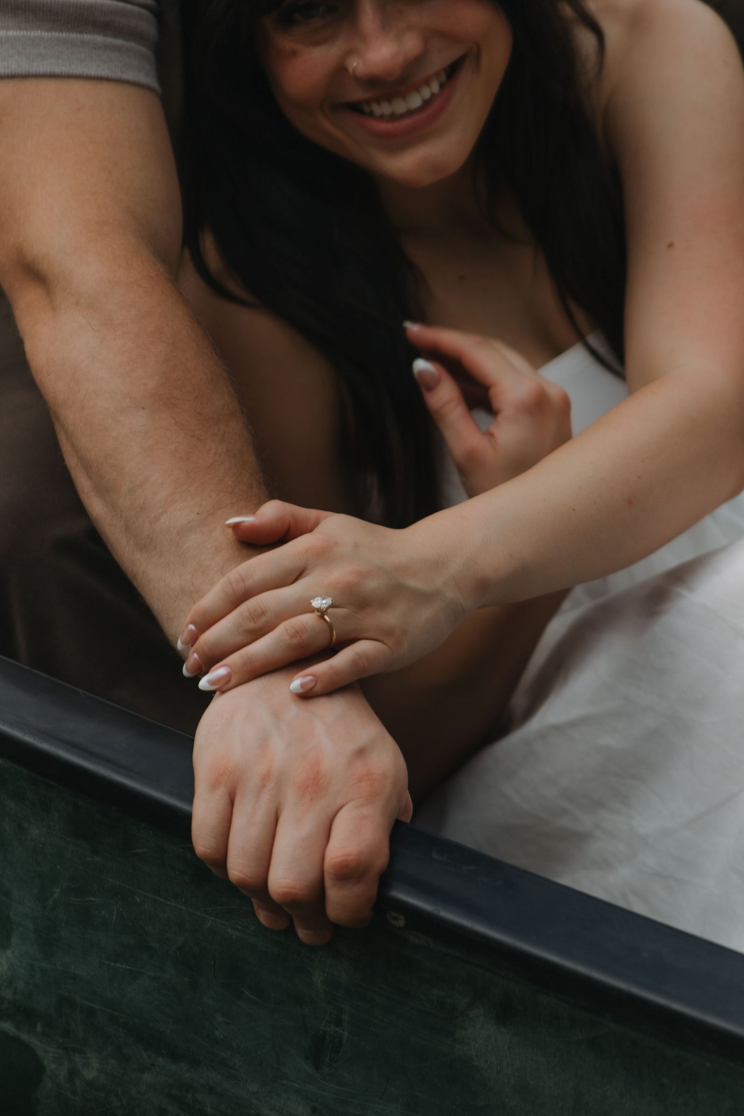 Close-up shots of intertwined hands against a dark background show tender moments of connection.