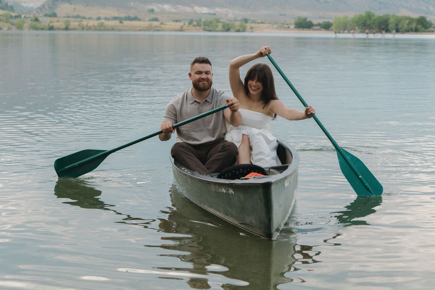 A couple enjoying a romantic canoe ride on a serene mountain lake.