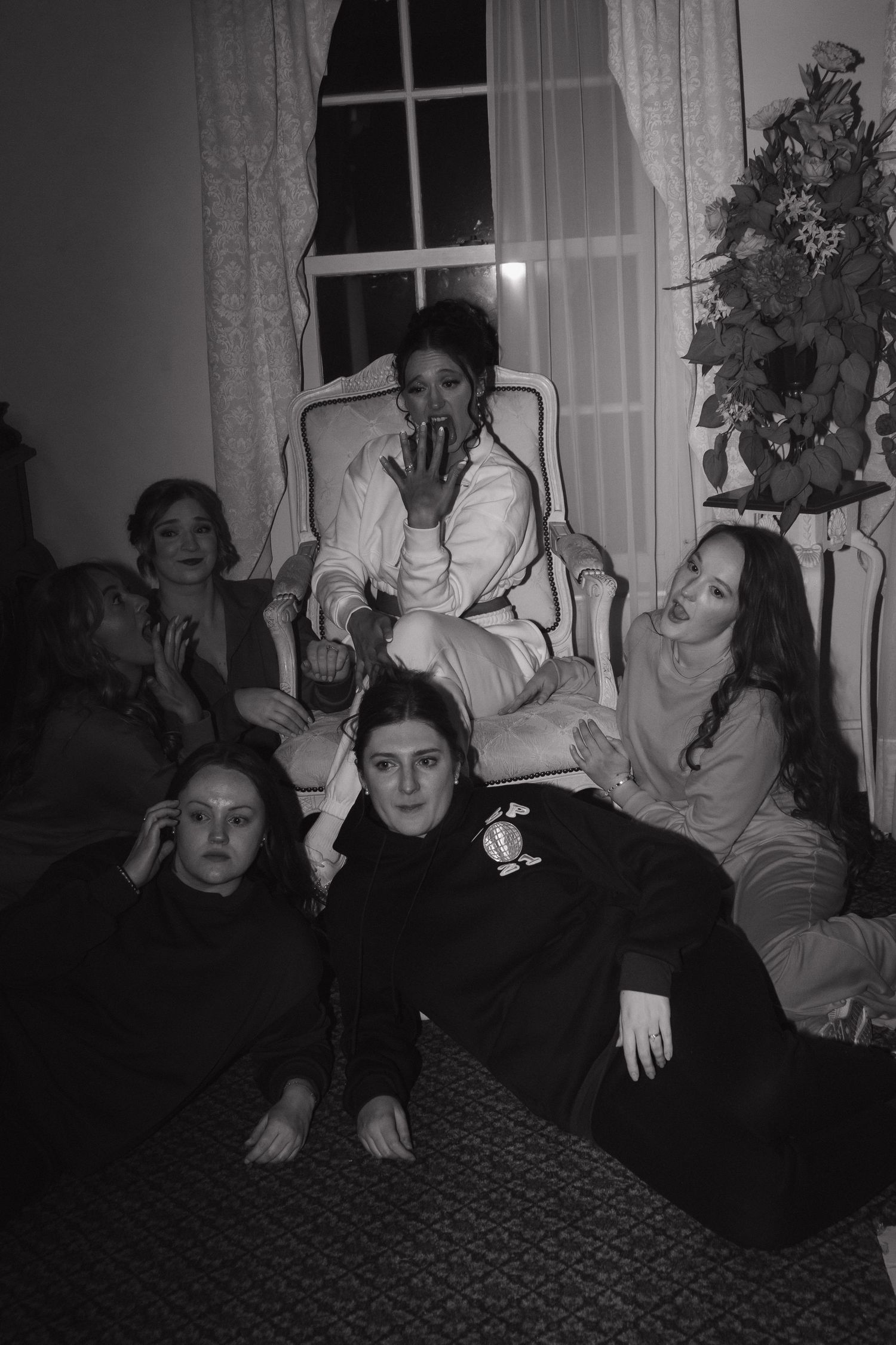 Playful black and white photo of wedding guests posing together.