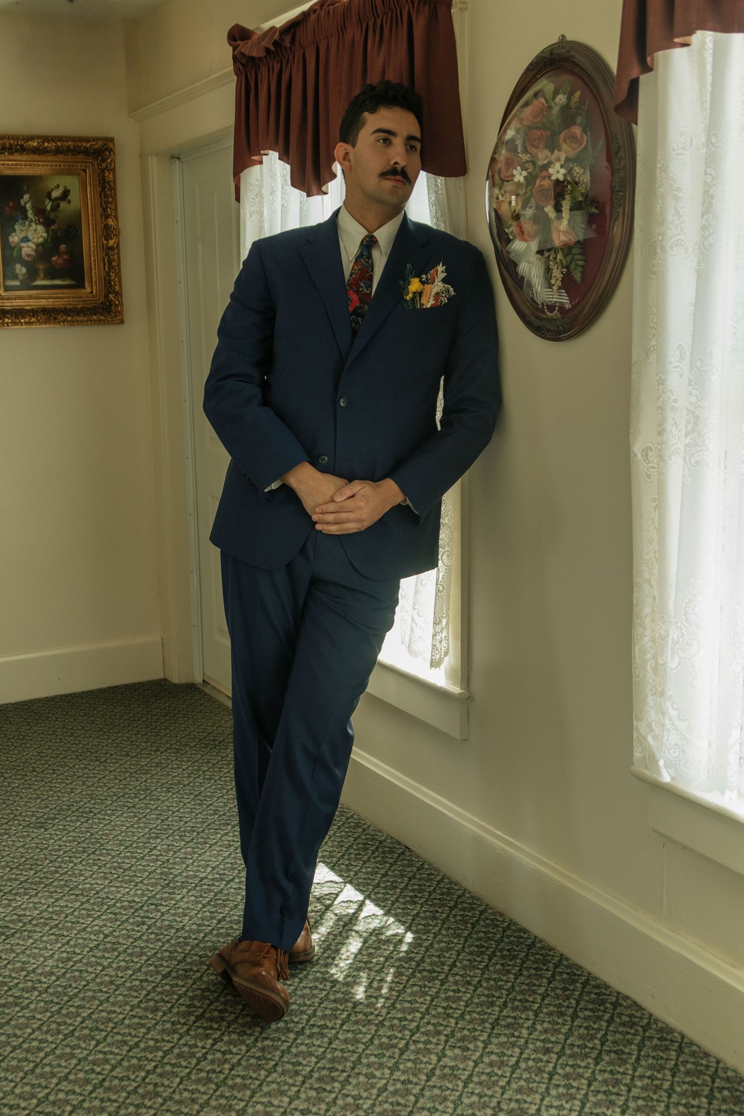 Series of shots showing a person in a navy suit walking through an elegant interior hallway.