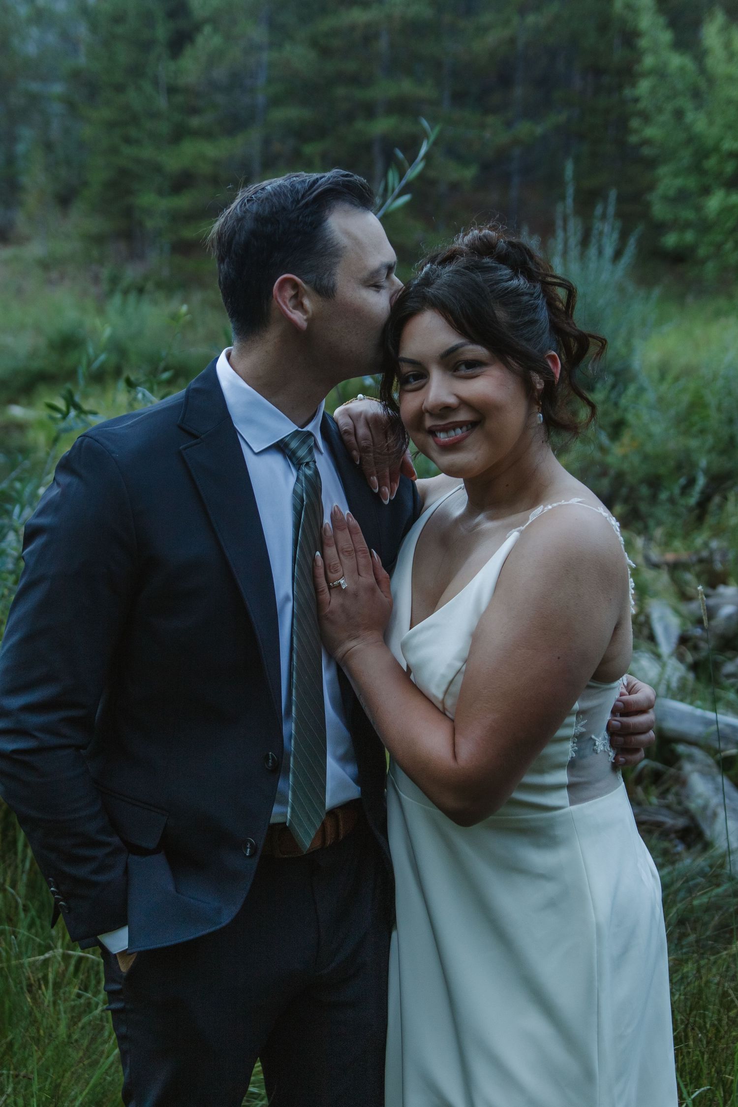 Candid moments of joy and laughter between newlyweds in a natural outdoor setting.