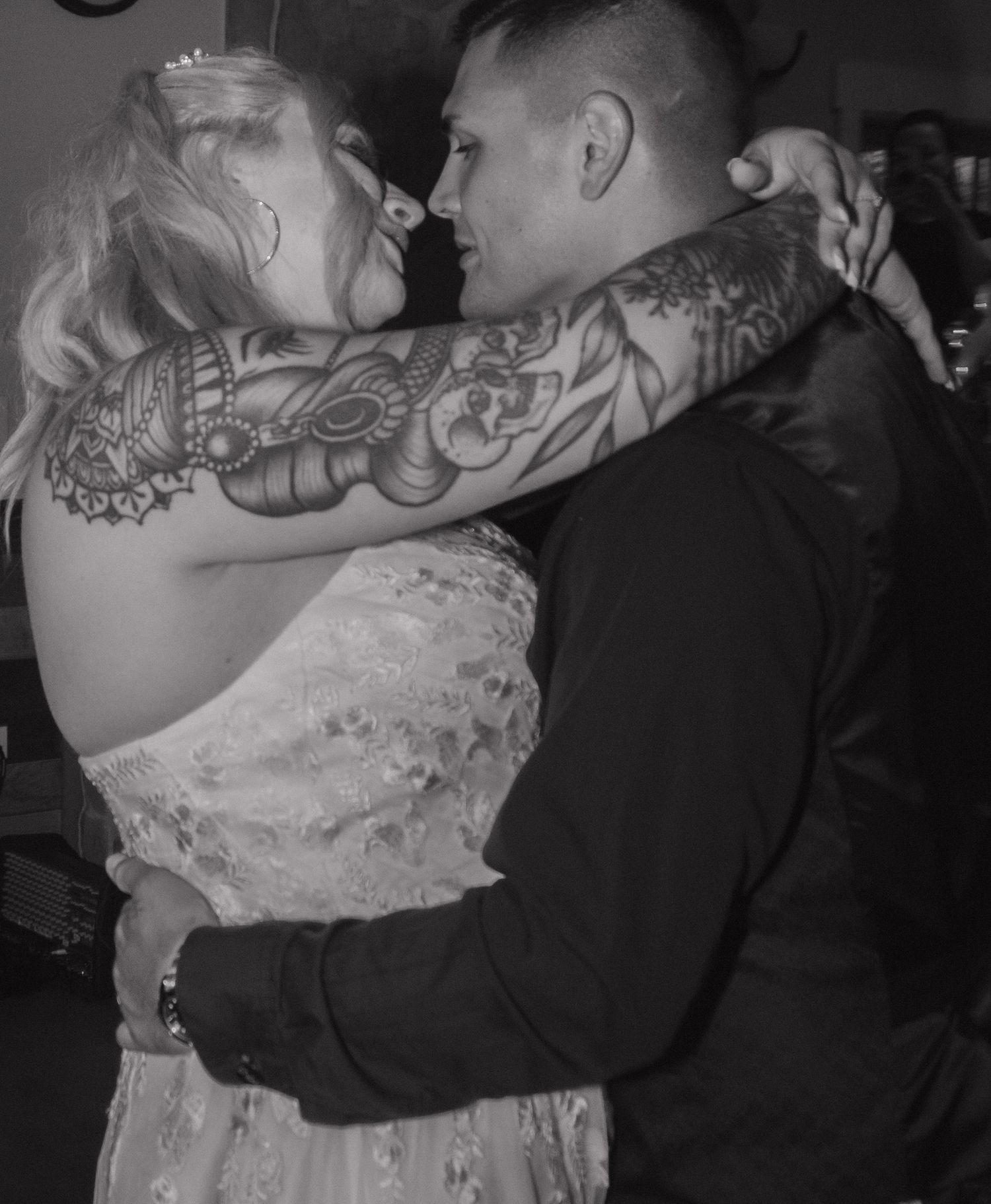 Black and white photo of couple embracing during wedding dance.