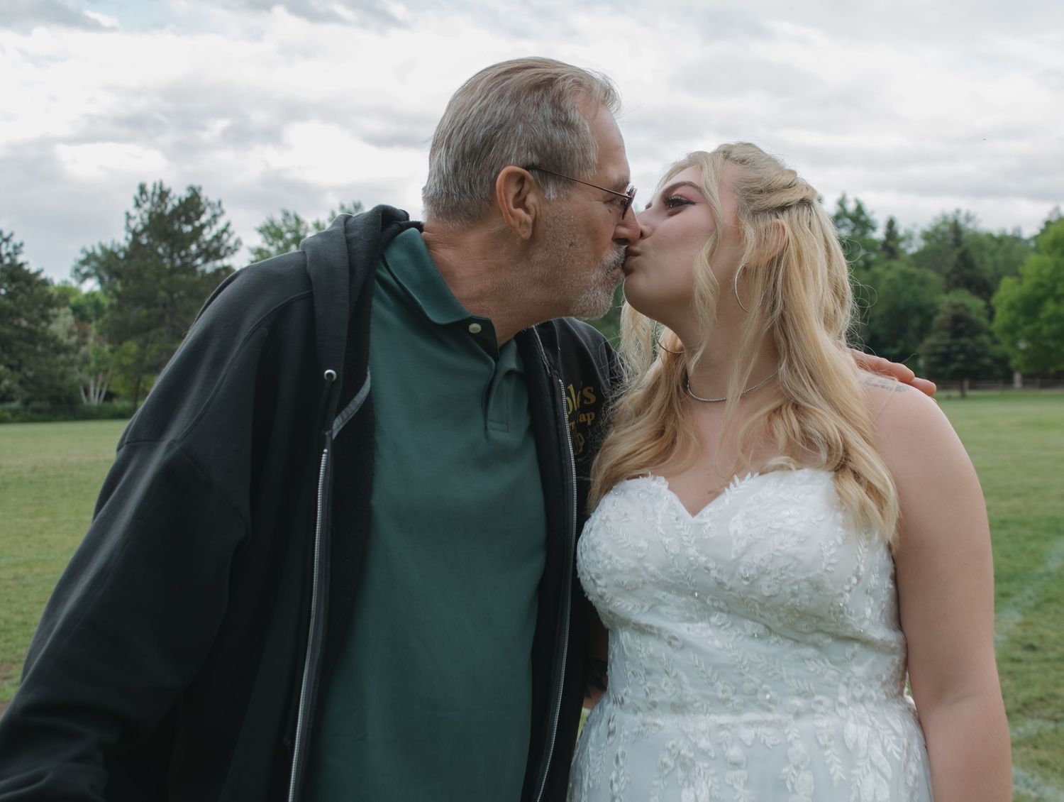An intimate moment shared between people during an outdoor photoshoot.
