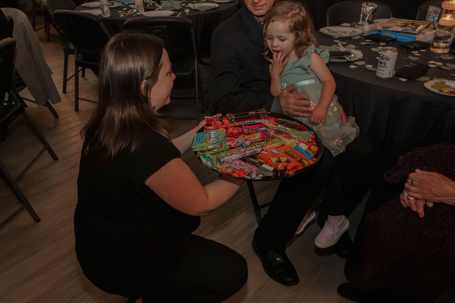 Person serving refreshments from a platter at an indoor celebration event.