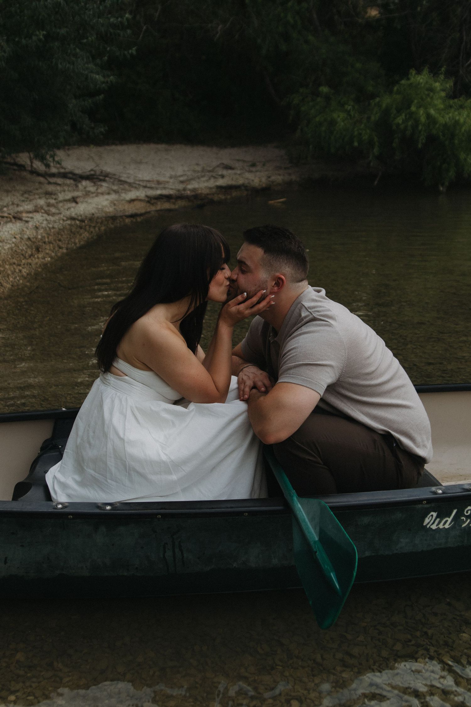 A couple shares a romantic moment together in a small boat on the water.