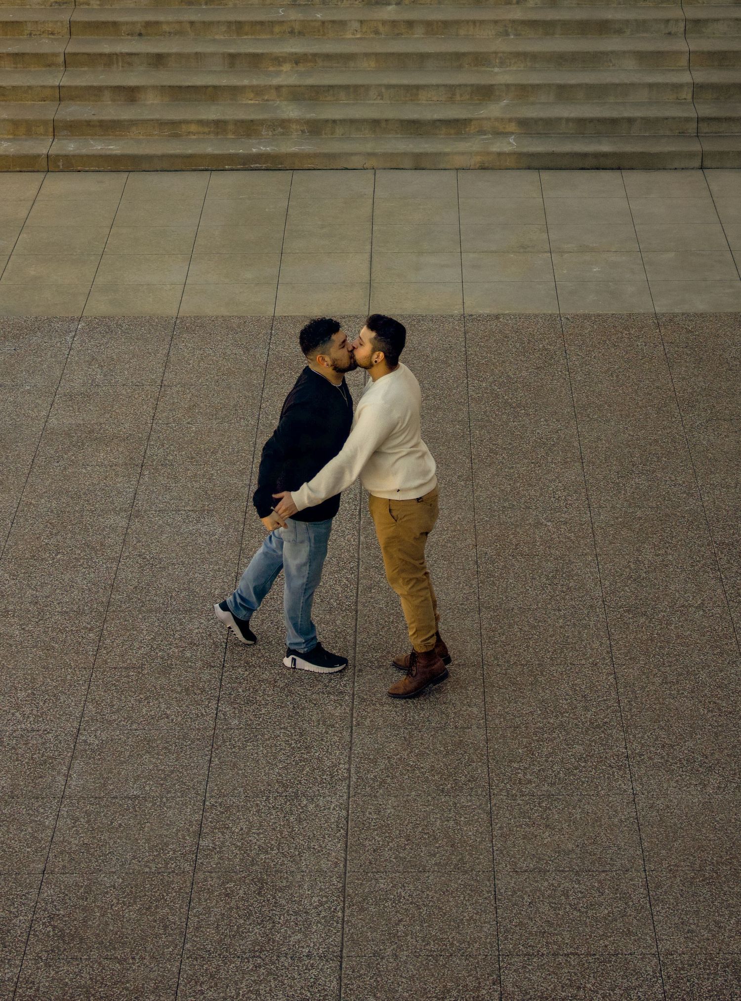 Two figures dance together on a concrete plaza, captured in a sequence of minimalist frames.
