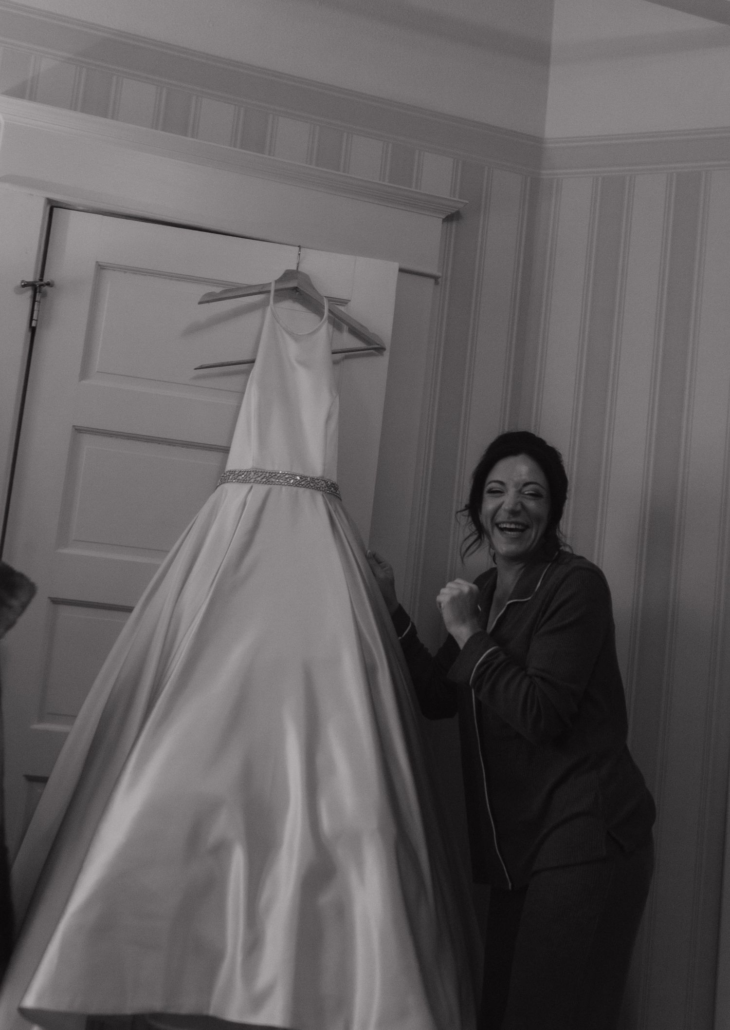 Four sequential photos show a wedding dress hanging in a room while someone in dark clothing stands nearby.