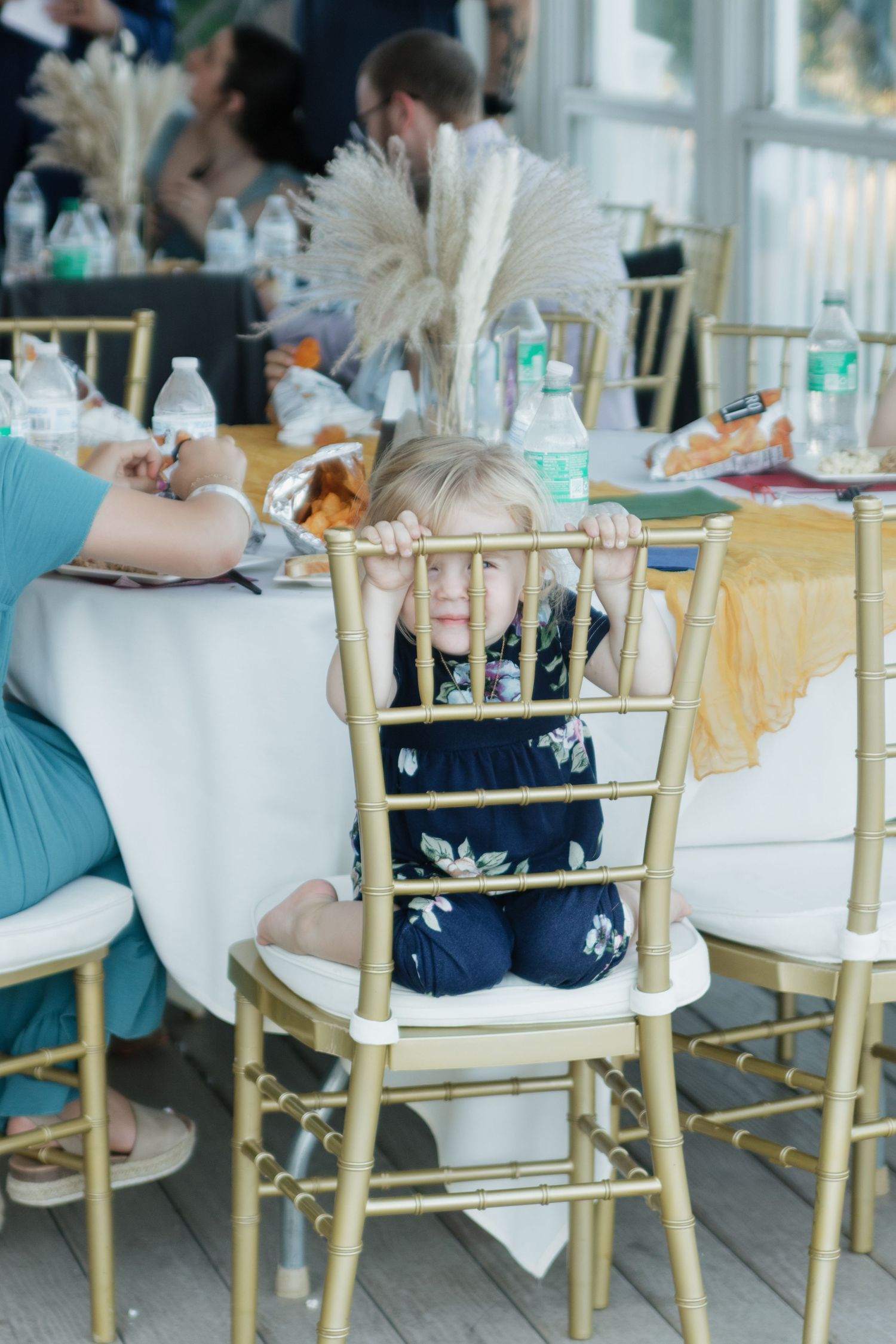 Reception table settings with gold chairs and elegant decor.