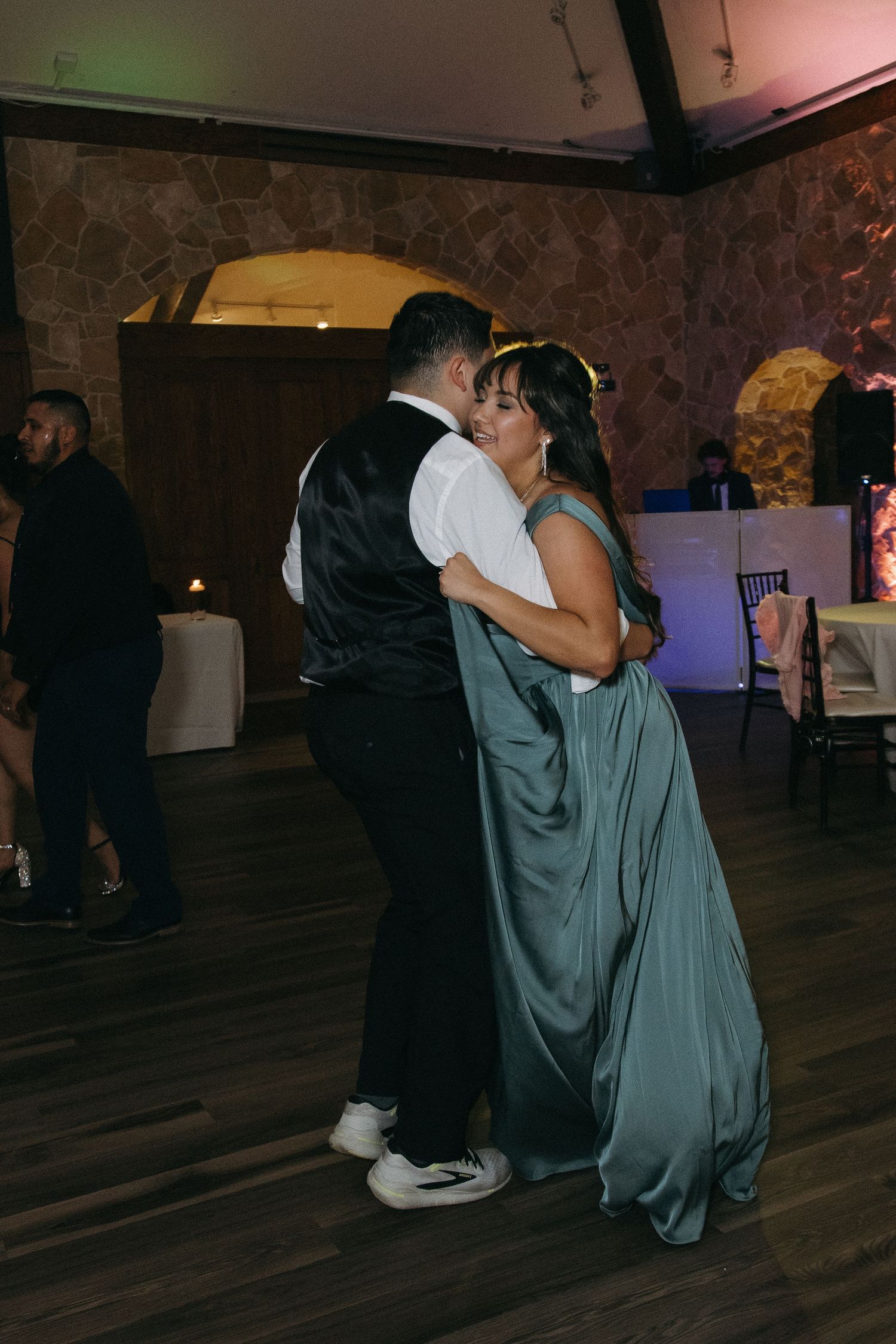 Mother and son sharing a tender dance at a wedding reception in a stone venue.