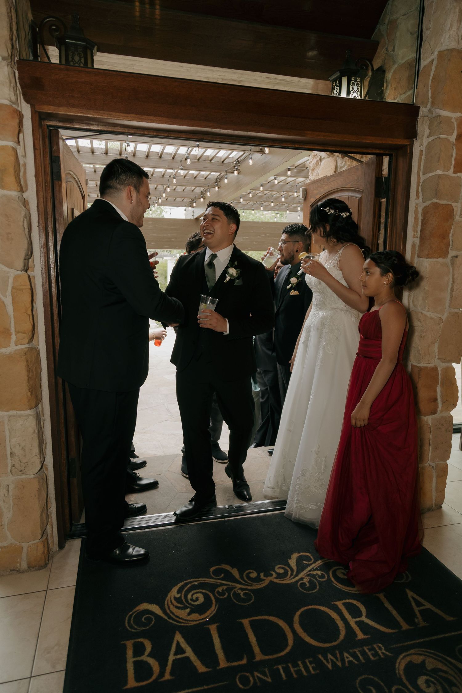 Wedding party arrives at Baldoria on the Water venue, greeted at the entrance doors.