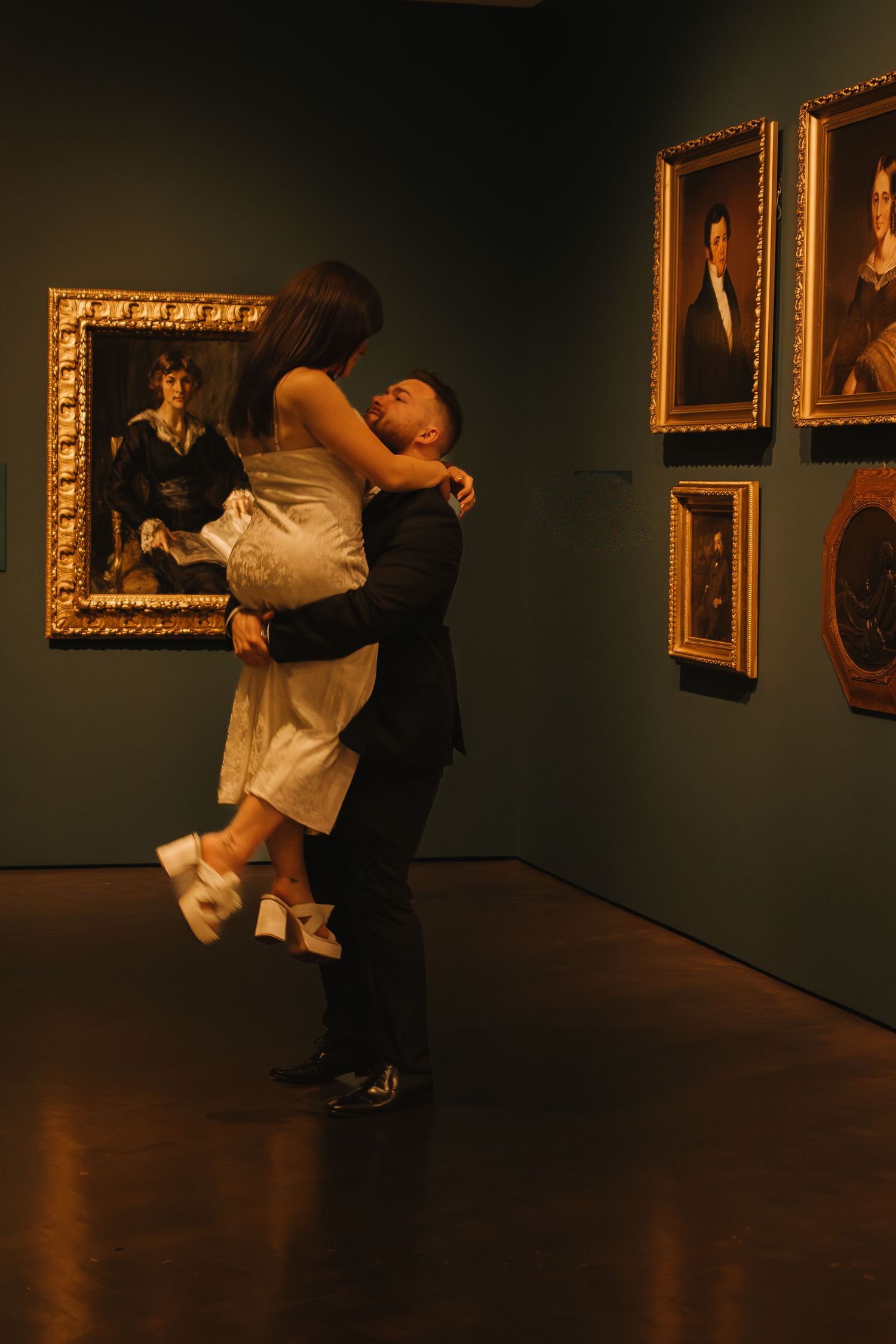 A couple performing an artistic dance lift in a museum gallery.